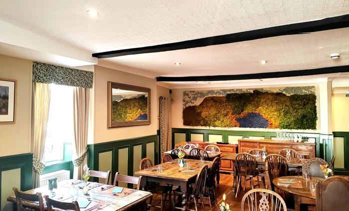 Our rustic dining room with fresh local flowers and our magnificent moss art piece custom made from local moss depicting the local landscape of Llyn y